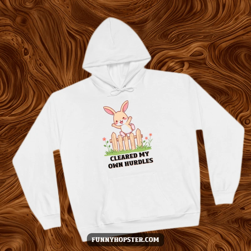 Funny rabbit character joyfully leaping over a small garden fence, printed on a warm and snuggly hoodie for ultimate comfort.